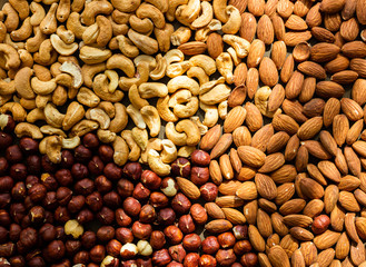 Nuts baked - almond, cashew, hazelnut in sun light, top view, healthy diet