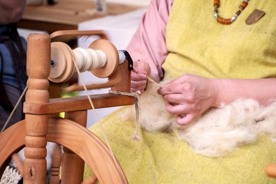 Altes Handwerk am Spinnrad, F&auml;den drehen am Spinnrad 