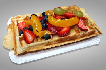Waffle with fruits - strawberries, blueberries, peaches and grapes