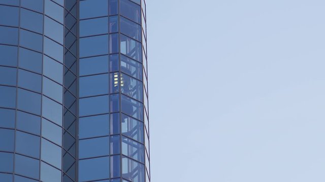 Glass Elevator Going Down the Glazed Facade of Skyscraper. Glass Curtain Facade Wall Background. Time Lapse