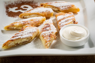 Crepes with cottage cheese and cream close-up