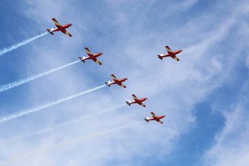 Plane show on a sunny day with cloud and blue sky in the background.