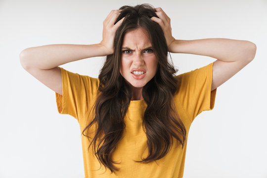 Image of confused resentful woman wearing casual t-shirt grabbing head in irritation
