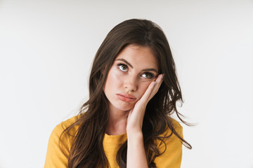 Image of young brunette woman wearing casual clothes propping up her head with hand