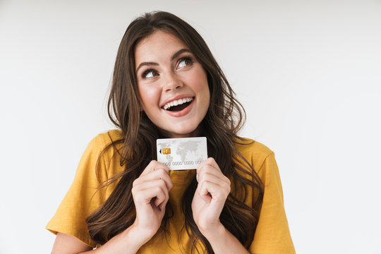 Image of caucasian brunette woman wearing casual clothes smiling and holding credit card