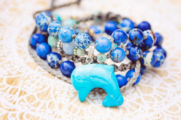 Dolphin mineral stone turquoise pendant bead necklace on decorative background