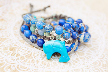 Dolphin mineral stone turquoise pendant bead necklace on decorative background