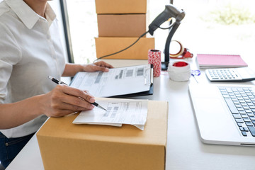 Young entrepreneur SME receive order client and working with packaging sort box delivery online market on purchase order and preparing package product, Small business parcel for shipment
