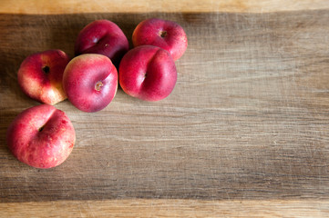 Six nectarines on a wooden piece. There is space for the inscription on the right.