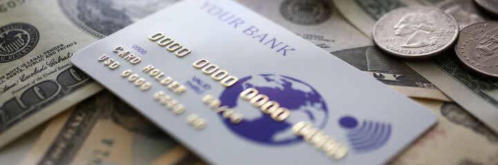 Banking plastic card lying on big amount of US money closeup