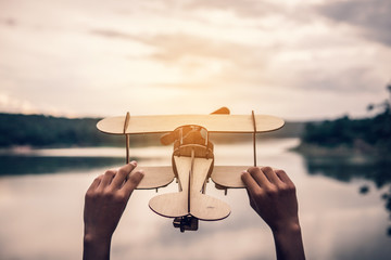 Hand holding wood airplane in the nature background,freedom to travel concept.