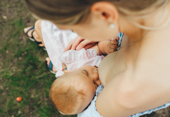 Lovely baby breastfeeding in nature.