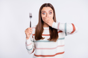 Crazy lady hiding mouth with arm remind herself about taboo on night eating wear striped pullover isolated white background - obrazy, fototapety, plakaty