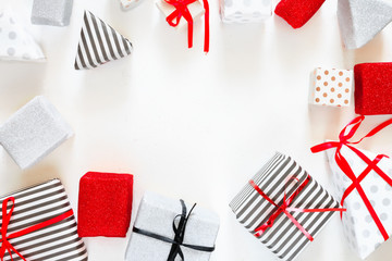 Flat Lay Christmas or party background with gift boxes, ribbons, decorations in silver, red and black colors. Flat lay, top view, xmas on white background