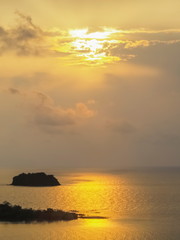 Naklejka na ściany i meble ew seaside evening of small island in the sea with yellow sun light background, sunset at Kai Bae View Point, Koh Chang, Trat Province, Thailand.