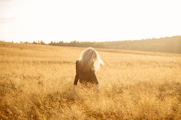Blonde beautiful girl portrait in the golden field.