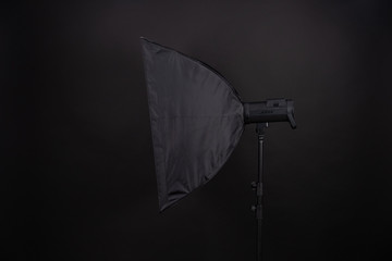 A softbox on the black background. A professional stripbox. Photo studio equipment.