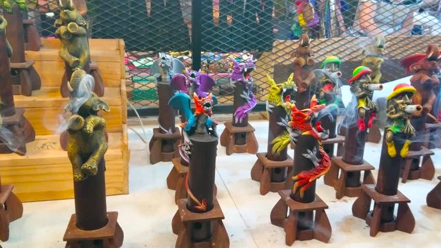 Handmade incense censers with figurines of rastaman, chameleon, elephant, dragon and other characters on the counter of souvenir stall in Chiang Mai Night Market, Thailand