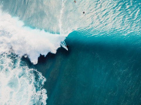 Aerial view of surfing at barrel waves. Blue wave in ocean and surfers
