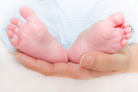 Mother holding her baby’s feet in her hand (two months old)