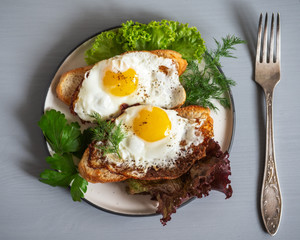 A quick Breakfast of sandwiches with scrambled eggs on lettuce leaves in a round plate