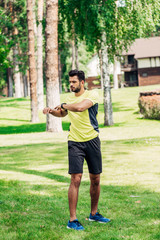 Fototapeta na wymiar handsome young sportsman working out in park on grass