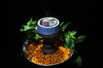 bowl with tobacco for hookah. berries on a black background