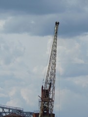 Obraz premium Port crane boom on a background of clouds.