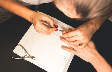 Obraz premium Woman is making a manicure. Salon procedures at home. Beautiful hands and nails.