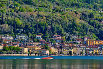 Fototapeta na wymiar Panoramic view of the center of Salo on Lake Garda, Italy. Reflections of city buildings by the water .