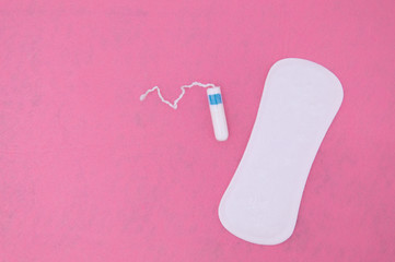 Female pads and tampon close-up on a pink background. Women's critical days.