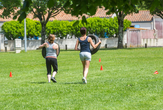 Women doing crossfit exercise outdoors - Powered by Adobe