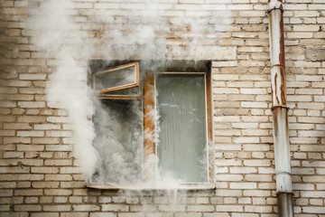 Picture of brick house with smoke coming out of window. - Powered by Adobe