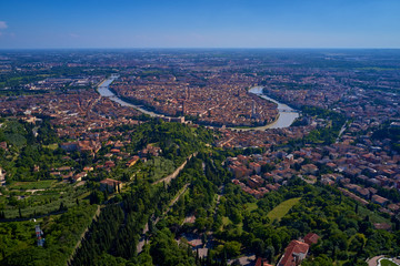 Adige river and fortified medieval castle of Castelvecchio. Aerial drone panoramic photo from  city of Verona. Verona, Italy.