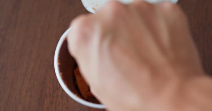 Eat potato chips from a paper cup