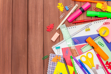 Back to school concept. School education supplies on brown wooden boards background