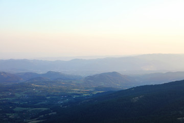 Mountain range with visible silhouettes through the evening fog.