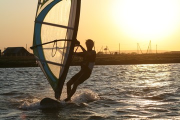 Fototapeta premium Windsurfer rides at sunset in the Black sea, Russia.