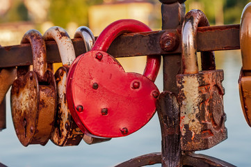 Many padlocks chained to the railing of the bridge