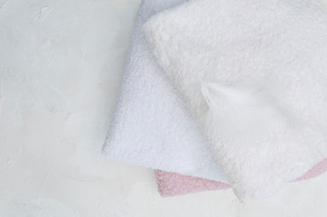 Top view of clean towels ad feather on it.Concept of soft and fluffy fabric