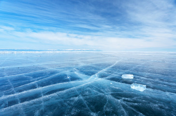 Winter landscape of frozen Baikal Lake. The endless fields of smooth blue ice and two transparent...