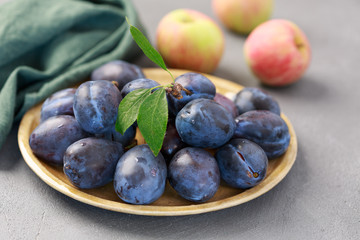 Farm plums on the concrete table. Significant antioxidant protection. Top view.