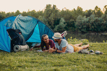 friends camping by the lake, drinking juice