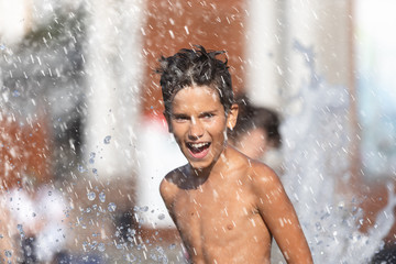 Happy children playing in a water fountain