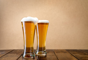 Two light beer glasses w on the light yellow background