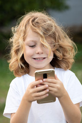 Funny child with long hair holding a mobile
