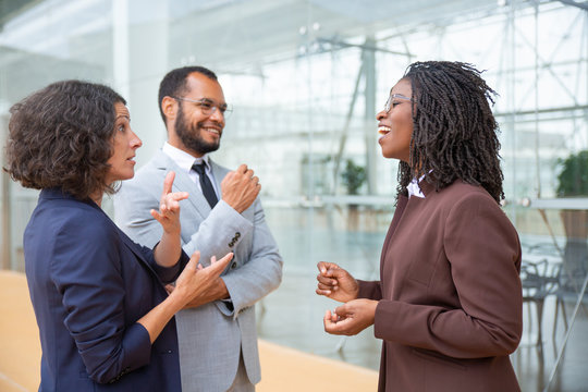 Cheerful multiethnic business team. Smiling male and female business colleagues standing together and talking. Teamwork concept