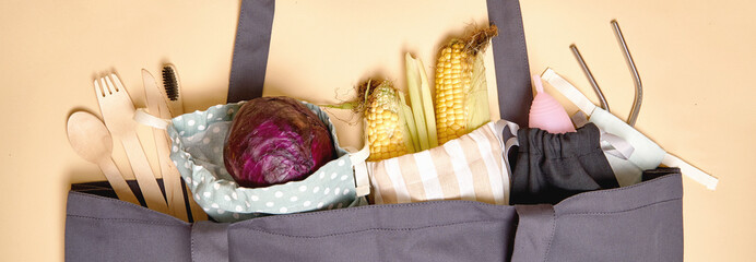 Grey shopper bag on beige background. zero waste. cutlery, toothbrush, metal straw banner