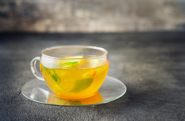 Glass cup of apple tea on dark grey background