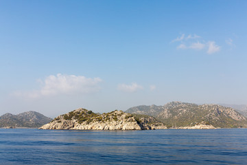 Mediterranean sea overlooking the mountains. Aerial top view of sea waves hitting rocks on the beach with turquoise sea water. Amazing rock cliff seascape in the coastline.